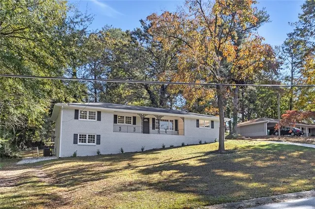 a view of a house with backyard and sitting area