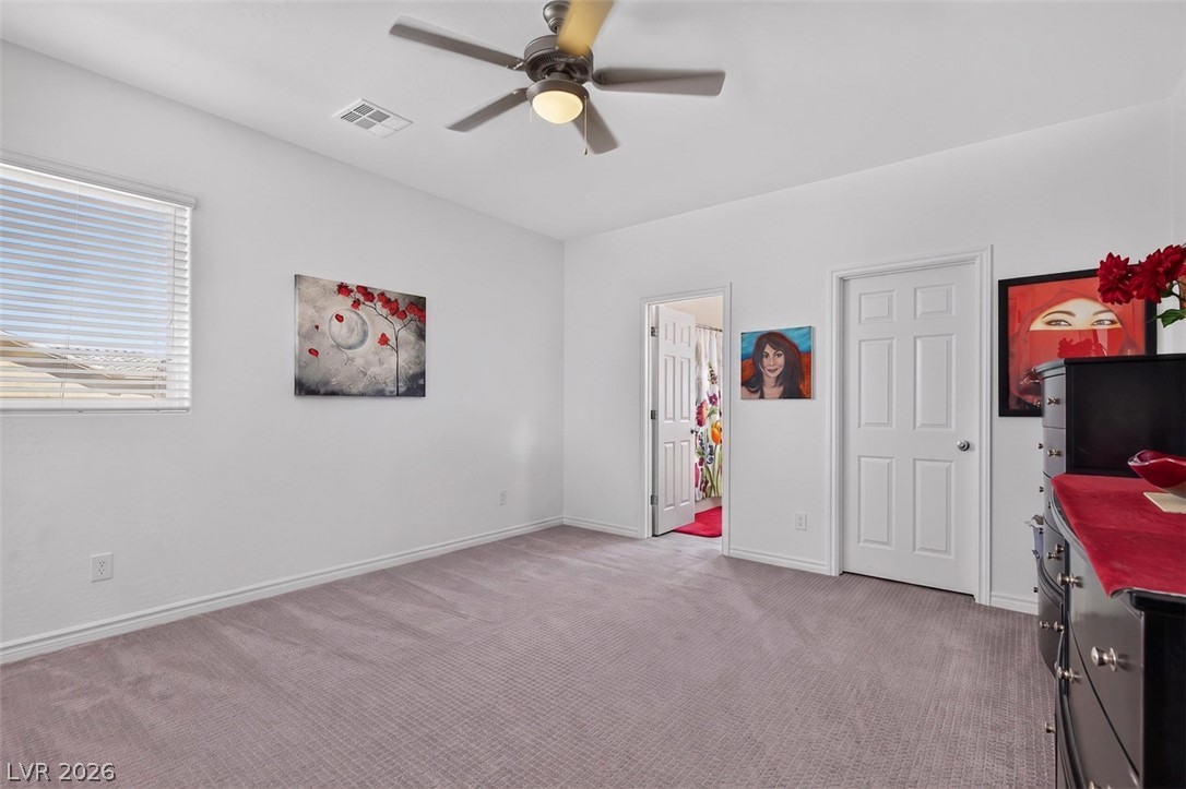 1824 Redland Ridge Street Henderson, NV 89002 - Photo 52 of 69 A well-lit bedroom features plush carpeting, a ceiling fan, and ample natural light from the window.