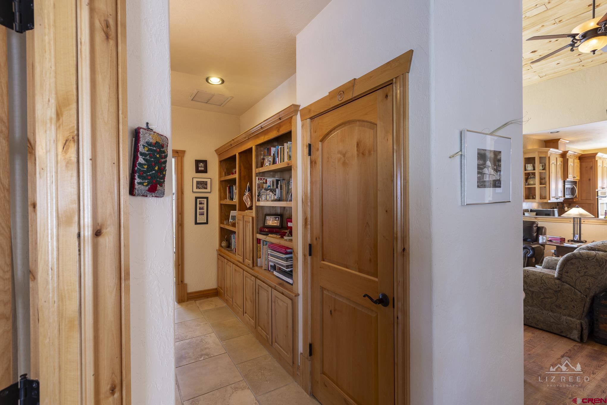 21602 Standingbear Road Cedaredge, CO 81413 - Photo 11 of 35 a view of a hallway with wooden shelves