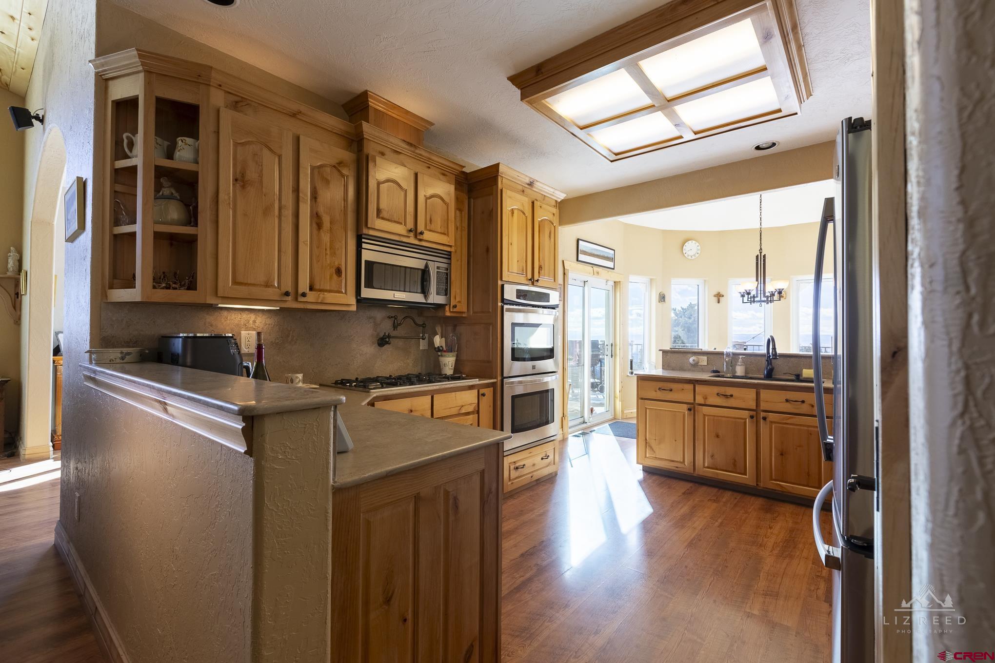 21602 Standingbear Road Cedaredge, CO 81413 - Photo 23 of 35 a kitchen with stainless steel appliances granite countertop a stove a sink and a refrigerator
