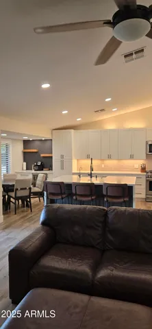 a living room with furniture a ceiling fan and a window