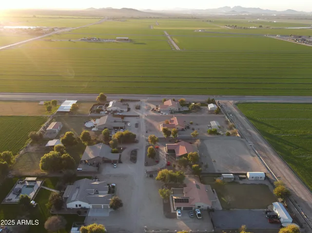 an aerial view of ocean and residential houses with outdoor space