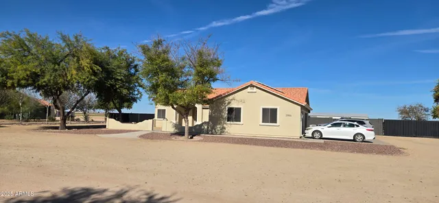 a kitchen with stainless steel appliances kitchen island granite countertop a refrigerator a stove a sink a dining table and chairs with wooden floor