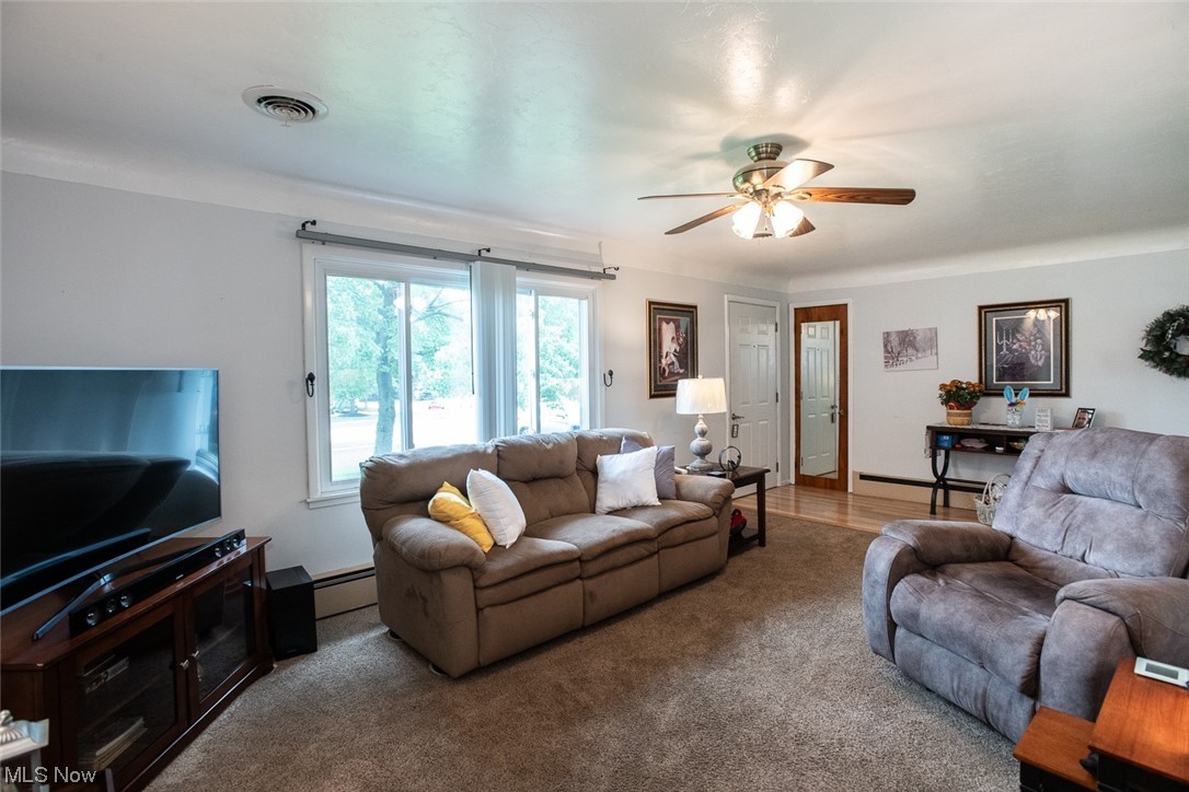 20873 Drake Road Strongsville, OH 44149 - Photo 6 of 25 Hardwood floored living room with a baseboard radiator and ceiling fan
