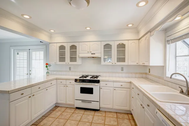 a kitchen with white cabinets stainless steel appliances and sink