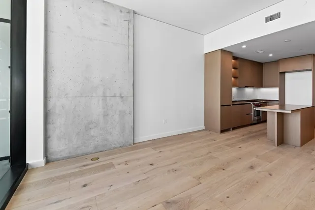 a view of a kitchen with refrigerator and white cabinets