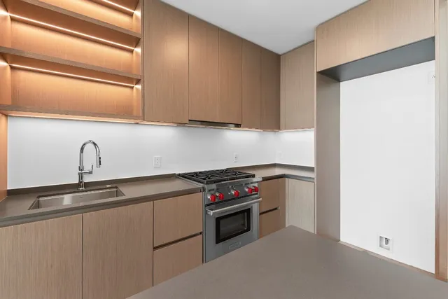 a kitchen with stainless steel appliances granite countertop a sink and a stove