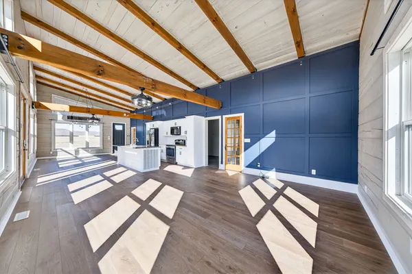 a view of a livingroom with wooden floor and a large window