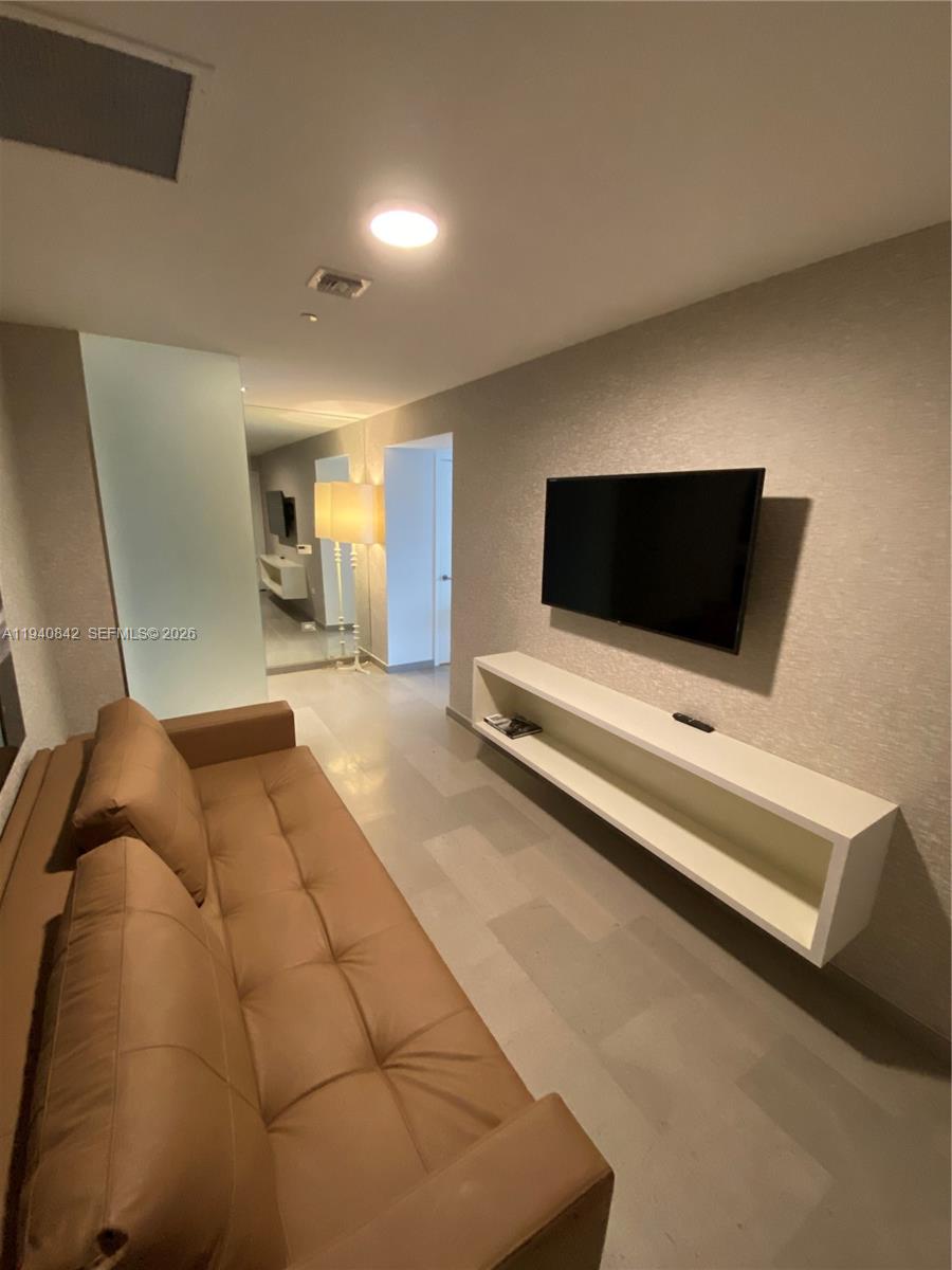 88 Southwest 7th Street, Unit 1904 Miami, FL 33130 - Photo 21 of 33 a living room with a couch and a flat screen tv