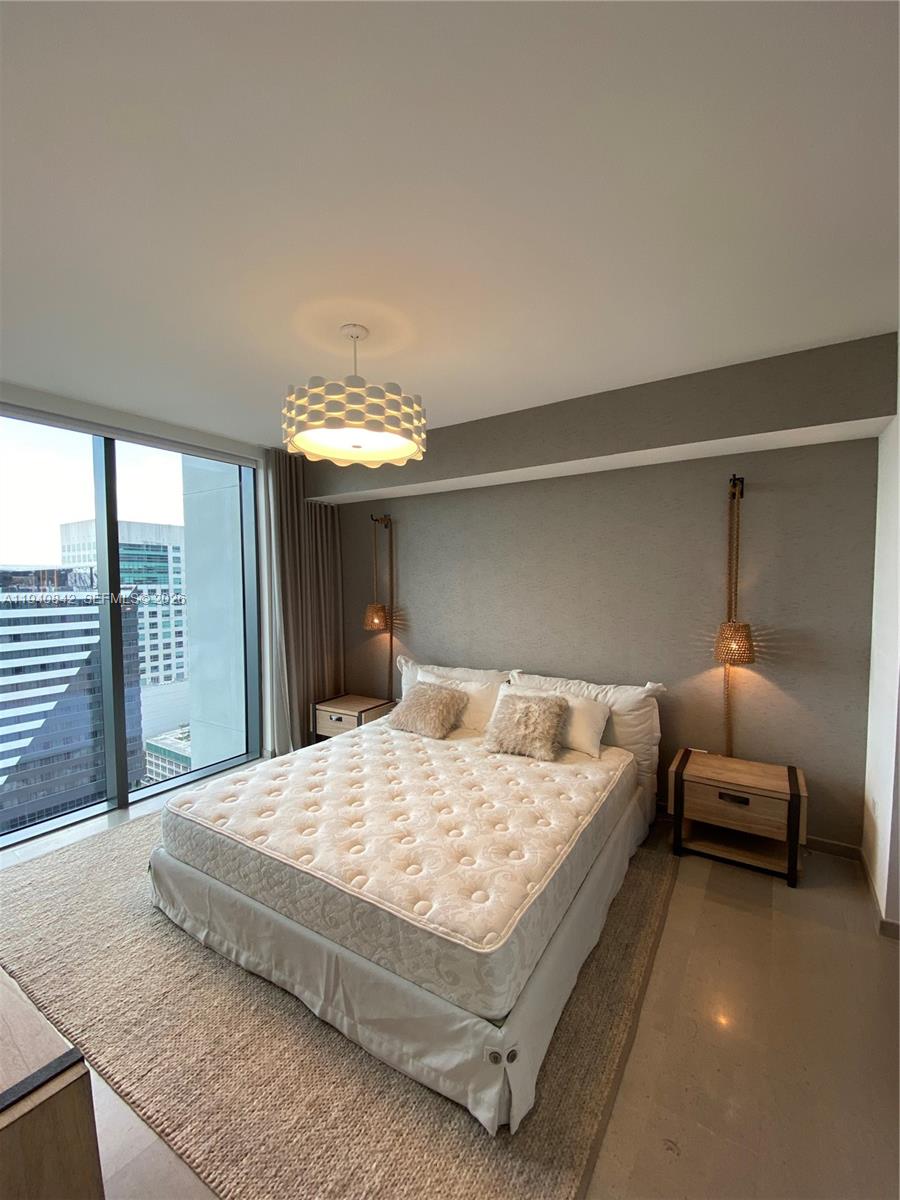 88 Southwest 7th Street, Unit 1904 Miami, FL 33130 - Photo 22 of 33 a bedroom with a bed and a large window