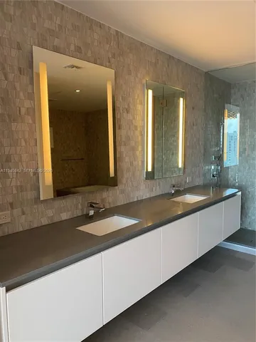 a bathroom with double vanity sinks and a large mirror