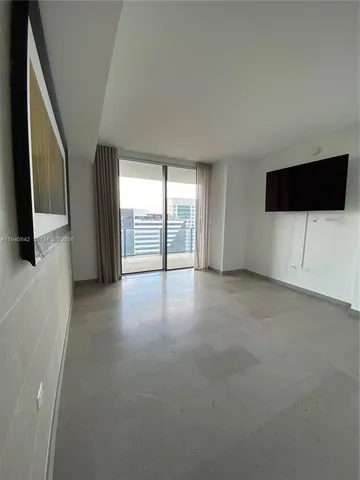 a view of a livingroom with an empty space and a flat screen tv