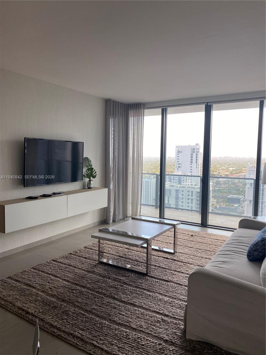 88 Southwest 7th Street, Unit 1904 Miami, FL 33130 - Photo 9 of 33 a living room with furniture and a flat screen tv