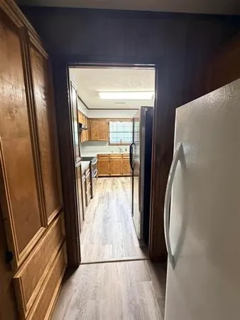a view of a hallway with wooden floor and door