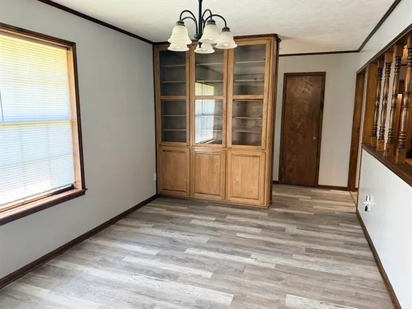 a view of a livingroom with wooden floor and windows