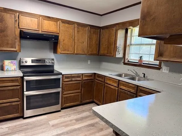 a kitchen with granite countertop a stove and cabinets