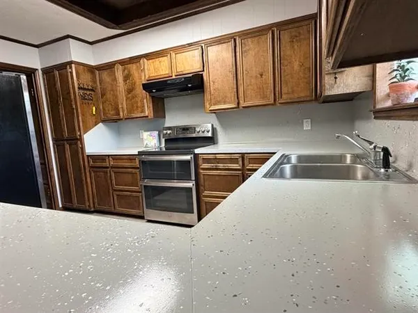a kitchen with stainless steel appliances a stove a microwave a sink and cabinets