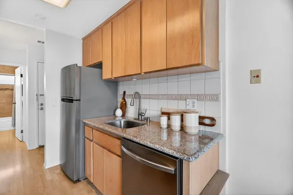 a kitchen with stainless steel appliances granite countertop a refrigerator and a cabinets