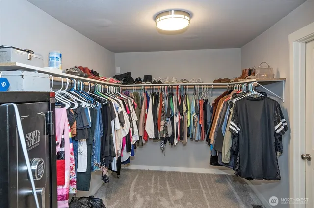 a view of walk in closet with clothes and shoes