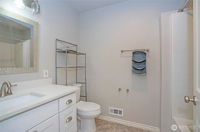 a bathroom with a granite countertop sink toilet and shower