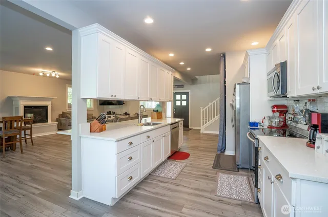 a kitchen with kitchen island granite countertop a sink cabinets and wooden floor