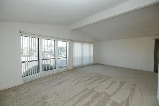 a view of an empty room with wooden floor and fence