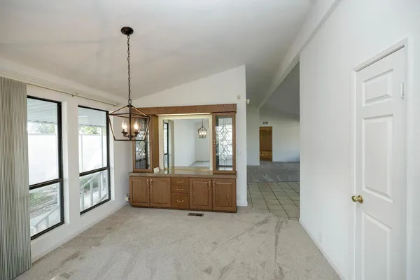 a view of an empty room with window and cabinet