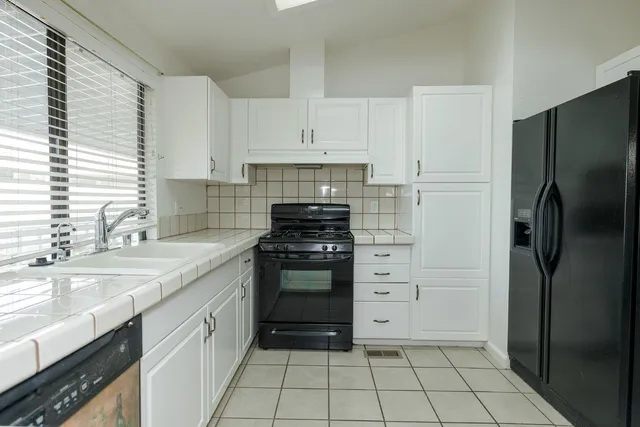 a kitchen with white cabinets and appliances