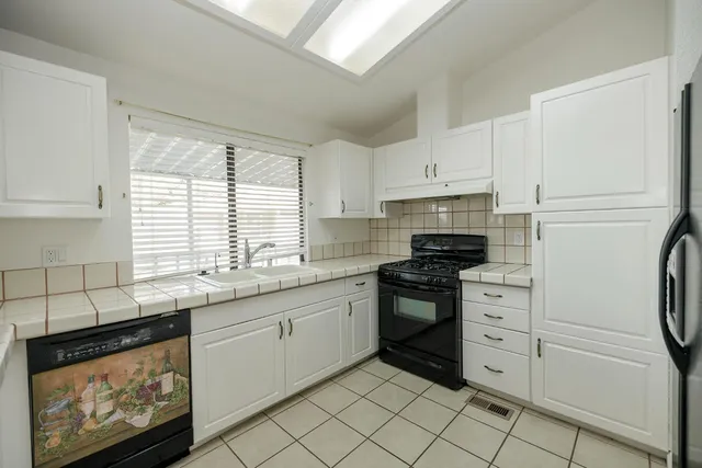 a kitchen with stainless steel appliances granite countertop a sink and a stove