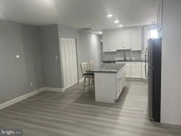 a kitchen with stainless steel appliances granite countertop a white cabinets and wooden floor