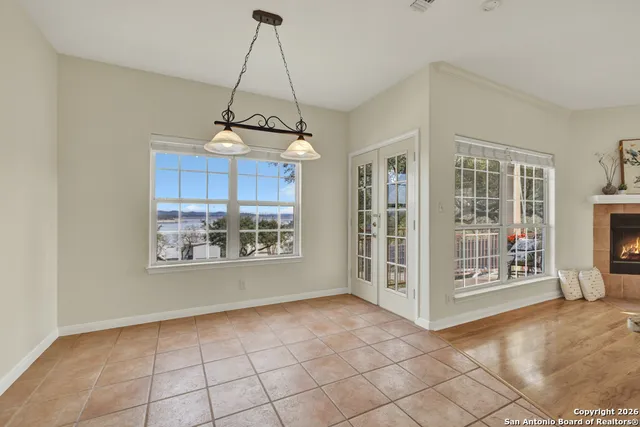 a large kitchen with granite countertop a refrigerator a stove a sink dishwasher and white cabinets with wooden floor