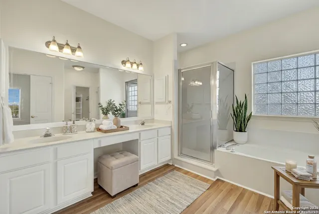 a bathroom with a double vanity sink a mirror and a bathtub