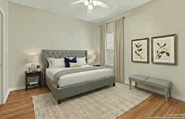 an empty room with wooden floor and fan