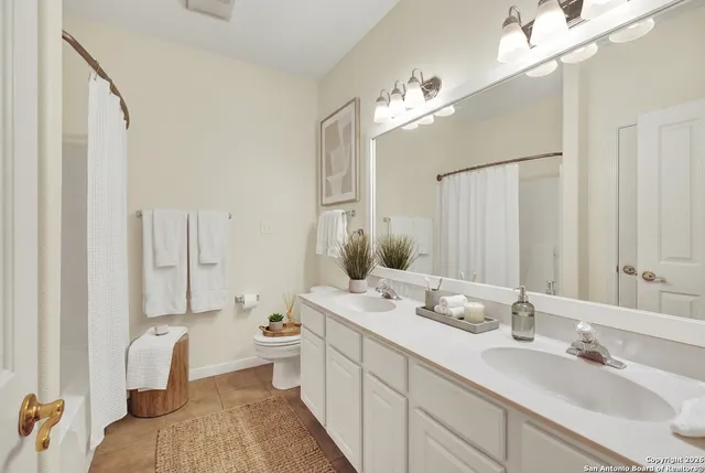 a bathroom with a double vanity sink mirror and toilet