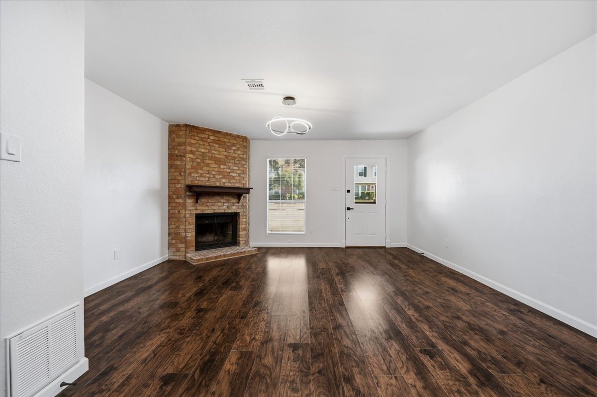 41 Abbey Road Euless, TX 76039 - Photo 5 of 23 Rich hardwood flooring complements a classic brick fireplace in this inviting living space.
