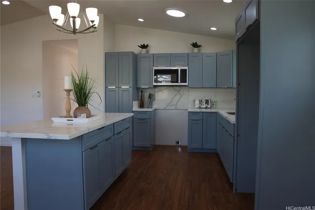 a kitchen with kitchen island granite countertop a sink stainless steel appliances and cabinets