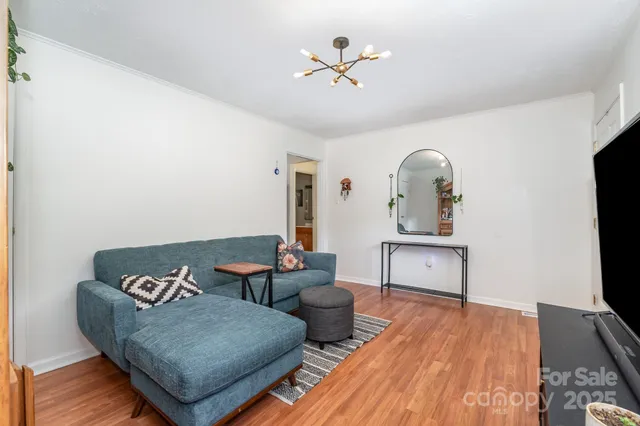 a living room with furniture a flat screen tv and wooden floor