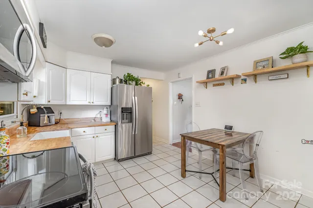 a kitchen with a refrigerator and a stove top oven