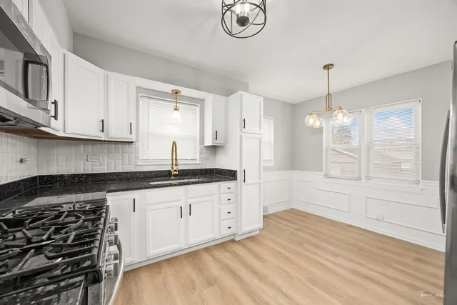 a kitchen with stainless steel appliances granite countertop a refrigerator a stove microwave and cabinets