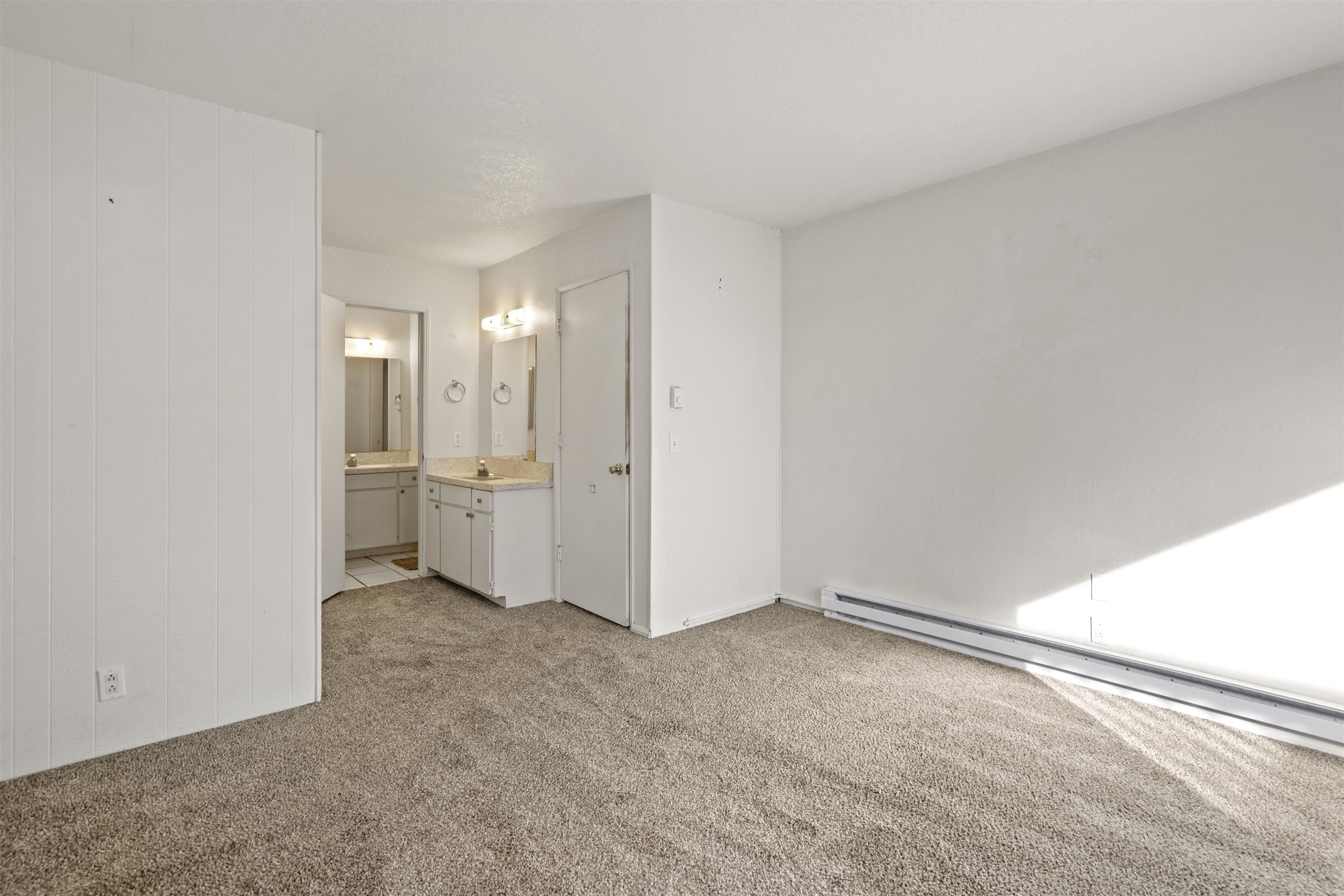3199 Chateau Road, Unit 18 Mammoth Lakes, CA 93546 - Photo 13 of 19 Unfurnished bedroom featuring light carpet, a baseboard radiator, and ensuite bath