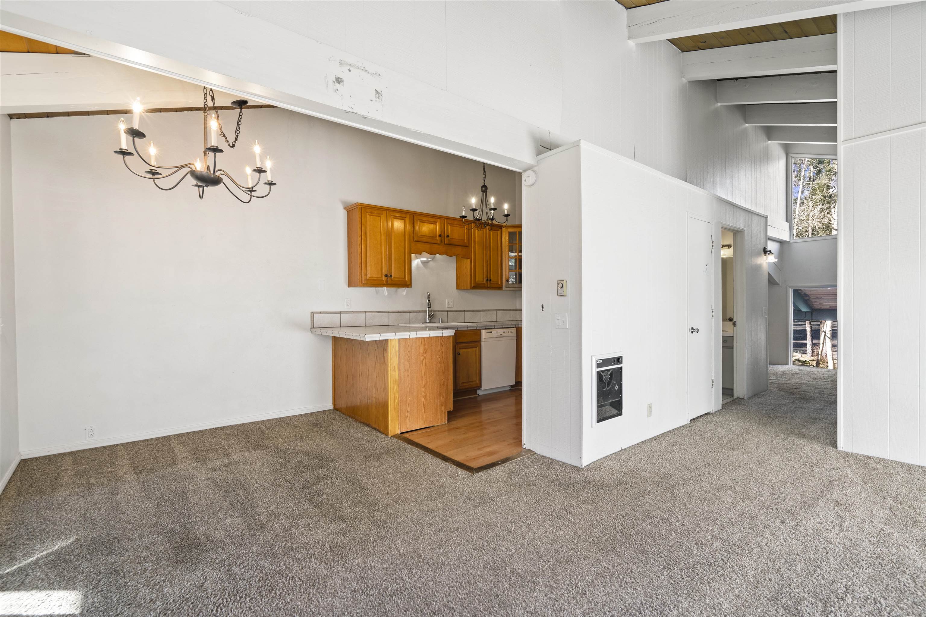 3199 Chateau Road, Unit 18 Mammoth Lakes, CA 93546 - Photo 4 of 19 Kitchen with carpet floors, brown cabinets, tile counters, a chandelier, and a high ceiling