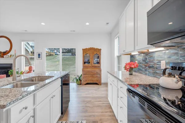 a kitchen with granite countertop a refrigerator and a stove top oven