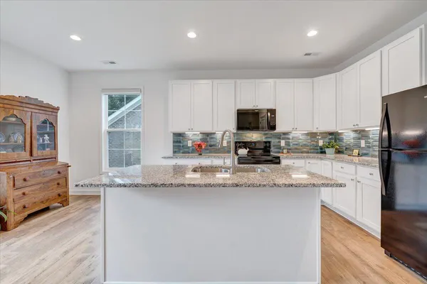 a kitchen with stainless steel appliances granite countertop a sink dishwasher stove top oven and cabinets