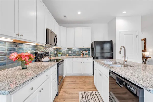 a kitchen with cabinets and wooden floor
