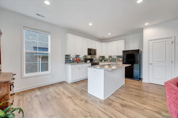 a kitchen with sink a microwave and cabinets