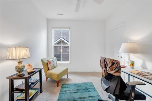 a view of a workspace with furniture and a window