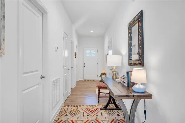 a living room with furniture a rug a fireplace and a large window