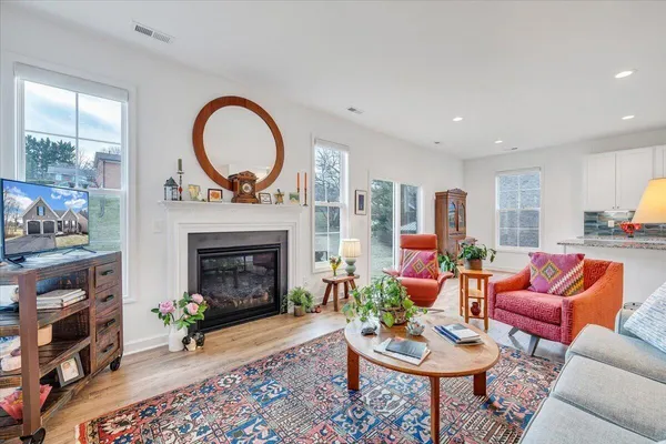 a living room with furniture fireplace and kitchen view