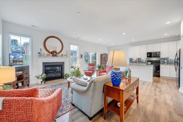 a living room with furniture and a dining area with rug