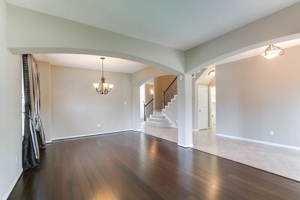 5803 Cedar Field Way Houston, TX 77084 - Photo 3 of 14 an empty room with wooden floor mirror and windows